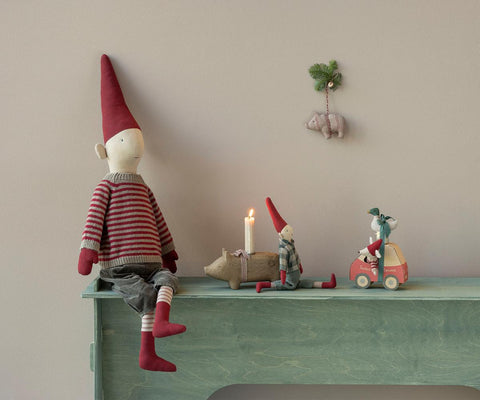 Christmas mouse doll in a red striped sweater, seated beside a toy car