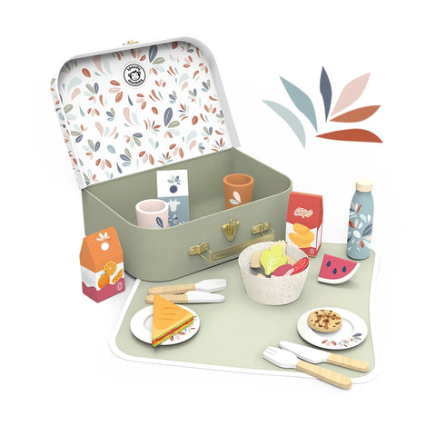 Open picnic basket with patterned lid and colorful lunch set on green mat