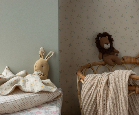 Bunny comforter peeking over a bed with its polka dot blanket