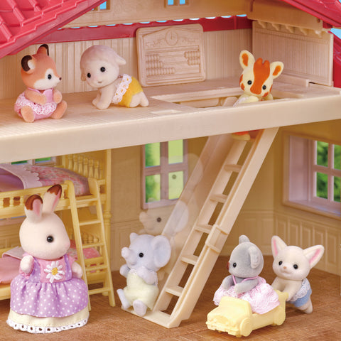 Dollhouse attic interior with bunny figurines on beds, ladder and windows